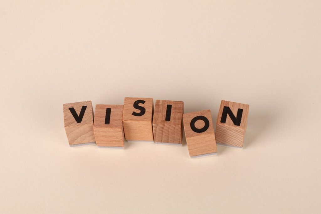 pexels photo 33105050 33105050 Wooden blocks with black letters spelling 'VISION' on a light beige background, symbolizing foresight and goals.