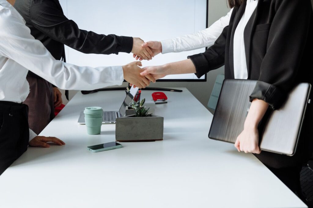 pexels photo 7651924 7651924 Professionals sealing a deal with a handshake across a conference table during a business meeting.
